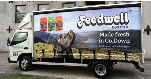 Building exterior with a Feedwell dog food truck in the foreground